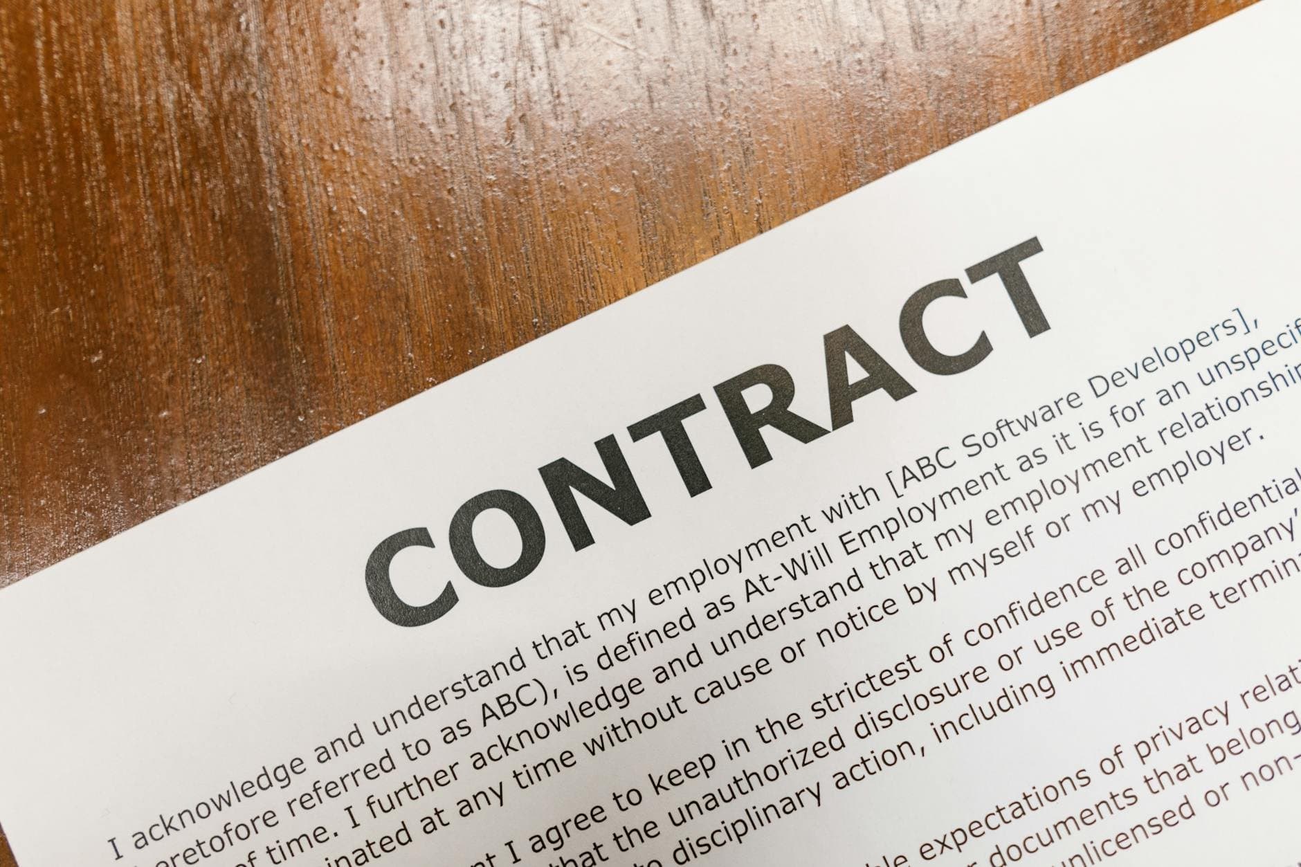 employment contract document with magnifying glass (Pexels)